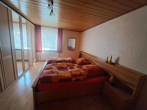 a bedroom with a bed in the corner of a room at Ferienhaus Hörbach - Die kleine Auszeit in Herborn