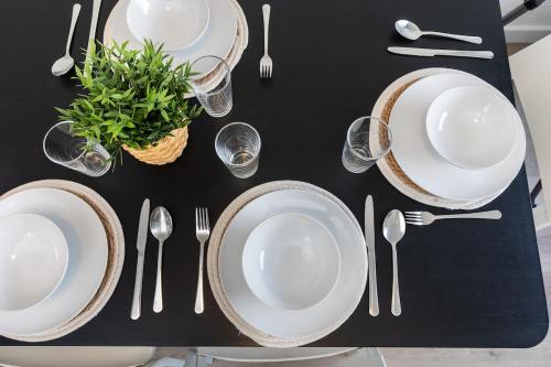 a black table with white plates and silverware on it at Komfortable Wohnung mit Terrasse für 5 Personen! in Baesweiler