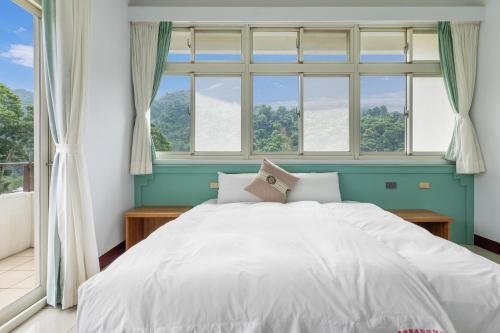 a bedroom with a large white bed in front of a window at 米堤園民宿 in Nanzhuang