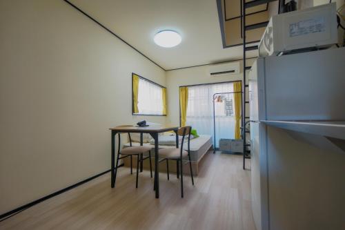 a kitchen with a table and chairs in a room at Corpo SKR by Tranova in Musashino