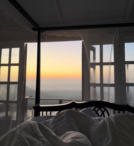 a bed in a bedroom with a view of the sunset at 4000Dao- A Hilltop Hideaway & Experience in Doi Tung 