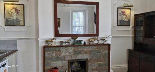 a living room with a fireplace with a mirror at Holly Lodge in Weston-super-Mare