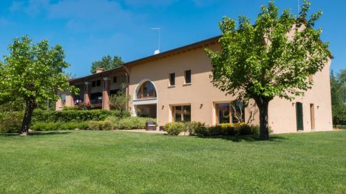 una casa con un césped verde delante de ella en Ca' del Sile en Morgano