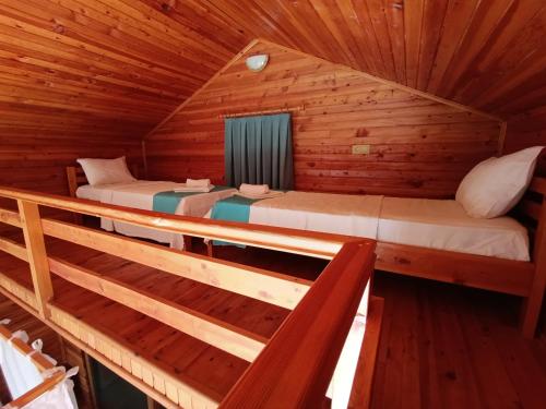 a room with two beds in a wooden cabin at Kabak Armes Otel in Fethiye