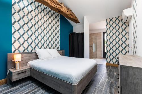 Schlafzimmer mit einem Bett und blauen Wänden in der Unterkunft L'Ecrin Du Chateau Canon Montségur in Les Salles-de-Castillon