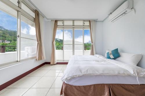 a bedroom with a bed and a large window at 米堤園民宿 in Nanzhuang