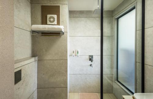 a bathroom with a shower with a glass door at Enrise by Sayaji, Vidisha in Vidisha