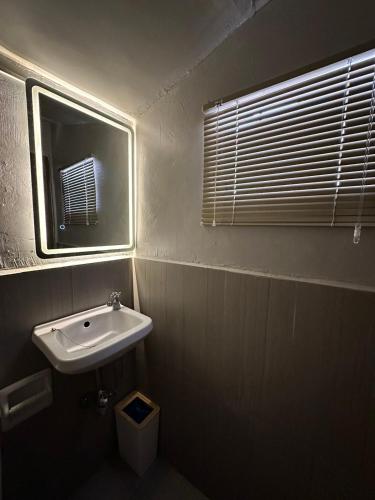 a bathroom with a sink and a mirror and a window at DY Casa in Puting Kahoy