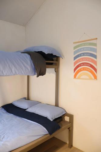 a room with two bunk beds and a sign on the wall at DY Casa in Puting Kahoy