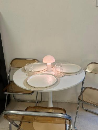 a white table with plates and wine glasses on it at DY Casa in Puting Kahoy