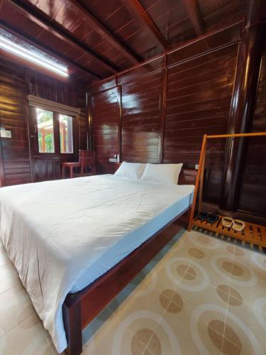 Un dormitorio con una cama en una habitación de madera. en Trutina's Home, en Ha Giang