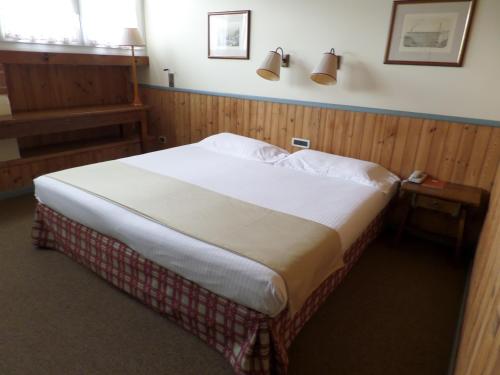 a bedroom with a large bed with two lamps on the wall at Hotel Miramonti in Schio