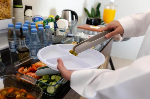 a chef is holding a bowl with a knife at فندق السليمانيه والرمال الزرقاء in Riyadh