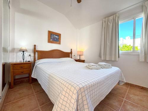 a bedroom with a bed with a checkered blanket at C Ntra Sra Maravillas 3 2A - Eurosur in Maro