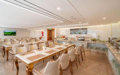 a restaurant with tables and chairs and a bar at Le Saigon Grand Hotel in Ho Chi Minh City