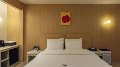 a bedroom with a bed and a picture of an apple on the wall at Browndot Hotel Jeonju Junghwasan in Jeonju