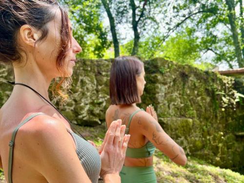 two women standing next to each other praying at Aldea Calma in Bordons