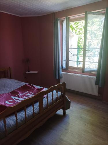 een slaapkamer met een bed en een raam bij L'annexe in Chalindrey