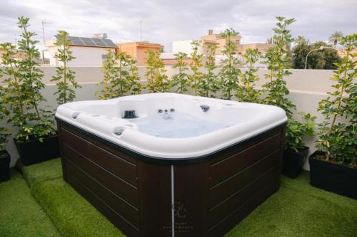 un jacuzzi en un balcón con plantas en Gc Luxury Apartments e Spa, en Santa Margherita di Belice