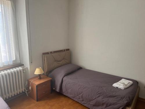 a small bedroom with a bed and a night stand at Da Pino Affittacamere in Madonna di Fornelli