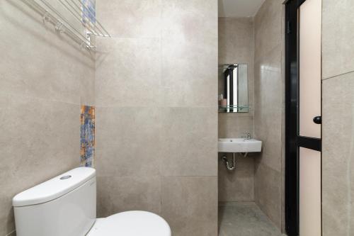 un baño con inodoro y lavabo en Urbanview Hotel Puri Indah, en Yakarta
