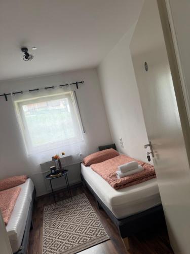 a small bedroom with two beds and a window at Main Weindorf Unterkunft in Sulzfeld am Main