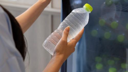 a person holding a plastic bottle in their hand at Browndot Hotel Jeonju Junghwasan in Jeonju