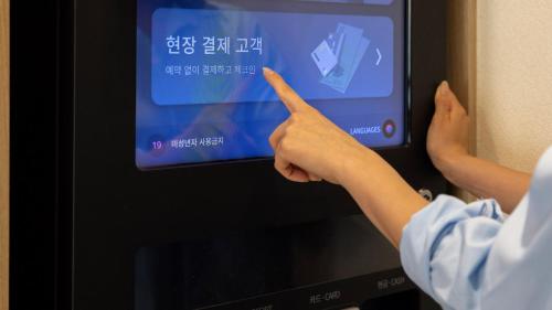 a person pointing to a computer screen with his hand at Browndot Hotel Jeonju Junghwasan in Jeonju