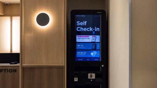 a self check in cell phone on a wall at Browndot Hotel Jeonju Junghwasan in Jeonju