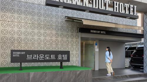 a woman standing in front of a store at Browndot Hotel Jeonju Junghwasan in Jeonju