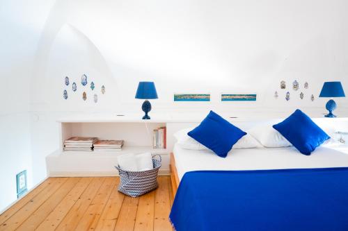 a bedroom with two beds and blue pillows at Casa William in Positano
