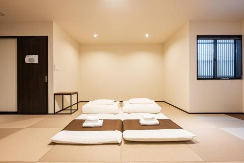 two beds in an empty room with towels on them at Irodori Hotel HOTARU in Fukuoka
