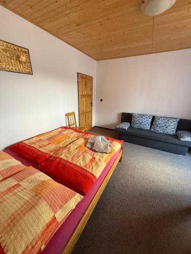 a bedroom with two beds and a couch at Pension U Krtka - přímo u sjezdovky in Harrachov