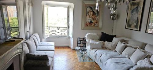 a living room with a white couch and a window at Villa Nanou Riviera in Nice