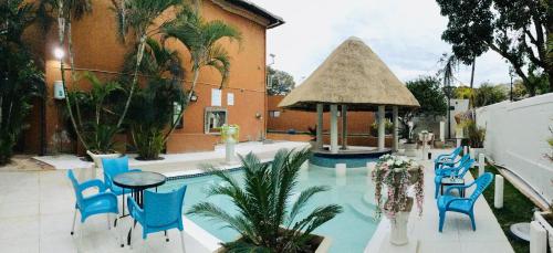 una piscina con sillas azules y un cenador en Labelva court Mosi oa tunya, en Lusaka