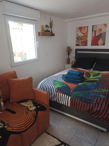 a bedroom with a bed and a chair and a window at Le Cosy chic in Saint-Maurice-de-Beynost