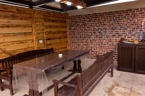 una sala da pranzo con tavolo e panche in legno di Harmony Escape a İsmayıllı