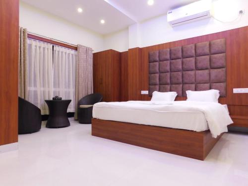 a bedroom with a large bed with a wooden headboard at ELITE Mandramoni in Mandarmoni