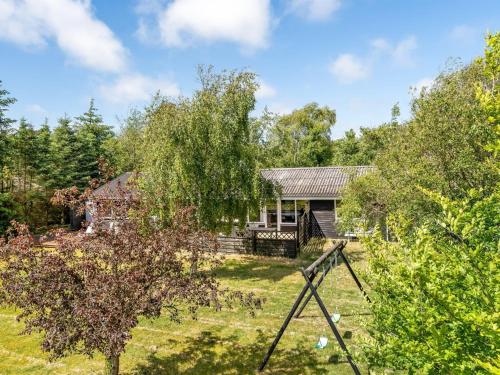 a house in the middle of a yard at Holiday Home Gerwin - 3km from the sea by Interhome in Blokhus