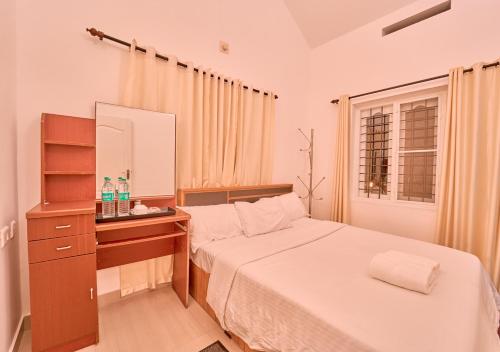 a bedroom with a bed and a dresser and a mirror at Kedara Resort Wayanad by VOYE HOMES in Sultan Bathery