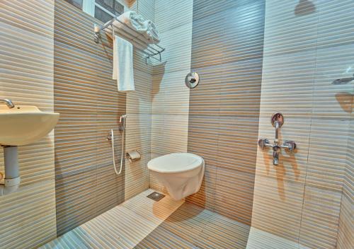a bathroom with a toilet and a sink at Kedara Resort Wayanad by VOYE HOMES in Sultan Bathery