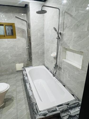 a bathroom with a shower and a bath tub at Résidence o-calme in Yaoundé