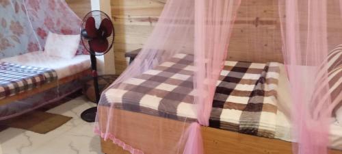 a bedroom with a bed with a curtain and a chair at Cheeky Mango Ella in Ella