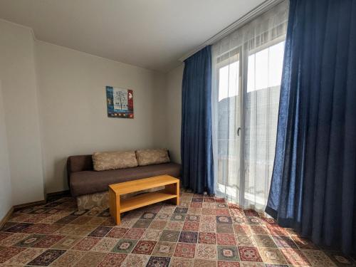 a living room with a couch and a large window at Hotel La Roka in Stara Zagora