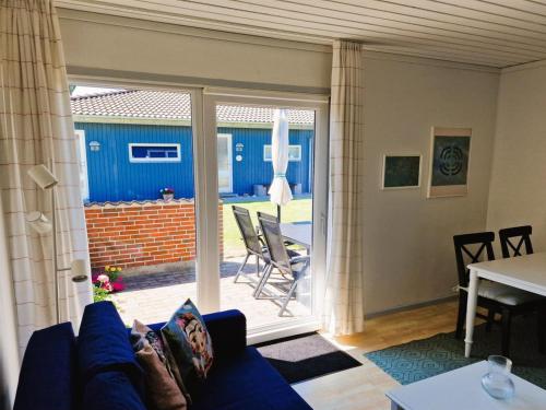 a living room with a blue couch and a sliding glass door at Apartment Emira - 50m from the sea by Interhome in Bogense