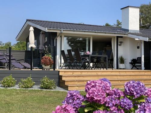 a house with purple flowers in the yard at Holiday Home Eddy - 50m from the sea by Interhome in Kragenæs