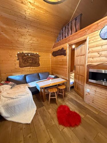 un salon avec un canapé bleu et une table dans l'établissement Romantyczny Zakątek z Jacuzzi Duo, à Ustrzyki Dolne