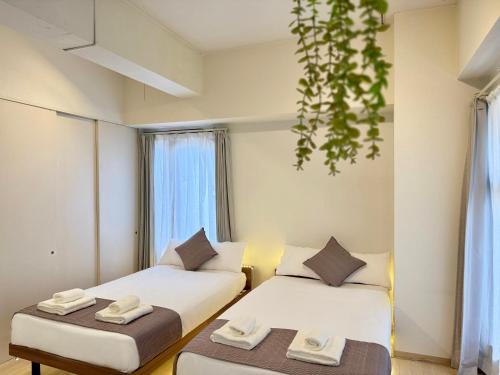 a hotel room with two beds and a window at Comfy Home Kikukawa in Tokyo