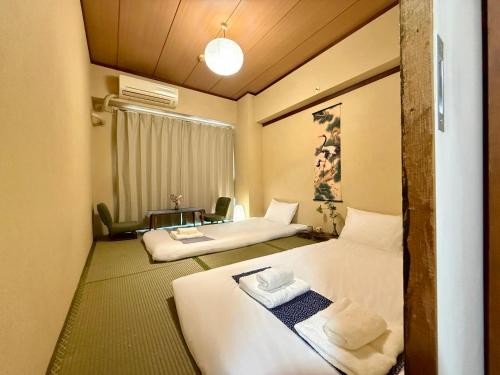 a hotel room with two beds and a table at Comfy Home Kikukawa in Tokyo