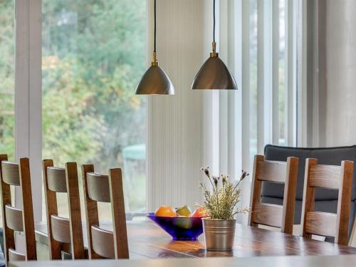 a dining room table with a bowl of fruit and two lights at Holiday Home Torhild - 150m from the sea by Interhome in Martofte